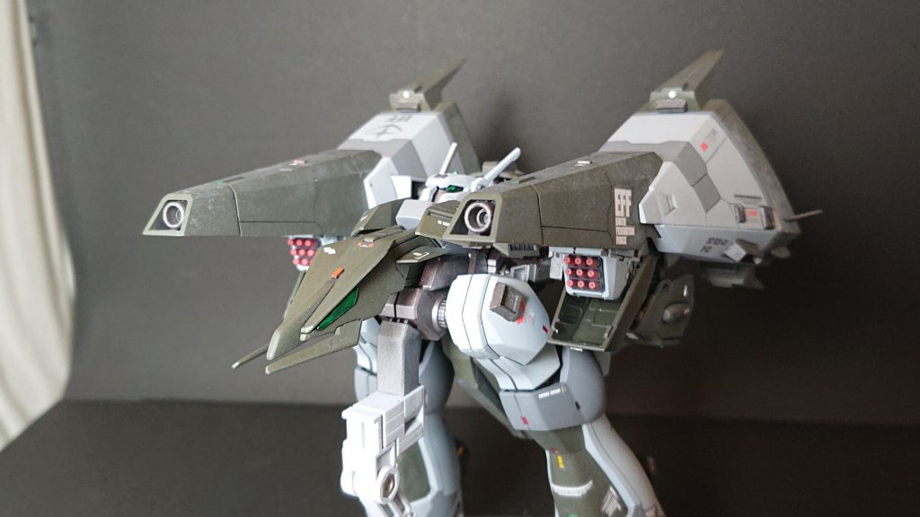 MA状態。スラスターユニットにはベース機同様のジェネレータ直結型、メガビーム砲を装備。よりメガ粒子の集束率を高め、通常地上では落ちる有効射程距離を、空間射程と比べてが60%まで伸ばす事ができた。
MS状態の両肩部に備える、9門ミサイルポッド。熱感知型でマルチロック(最大4ロック)可能。