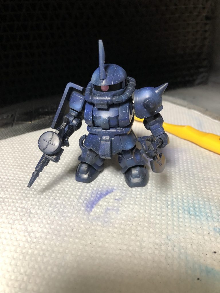 4色目、ガイアカラーコバルトバイオレット。
黒を塗り潰したコバルトブルーで塗装した範囲の内側を塗装。アクセントになってるホワイト以外がグラデーションになるはずです。そして全体にサッとひと吹き。
最後にもう一度ホワイトを歯ブラシで飛ばします。最初に飛ばしたホワイトはすでに4色くらいの色がついて明度が変わってます。星に距離感が出ます。