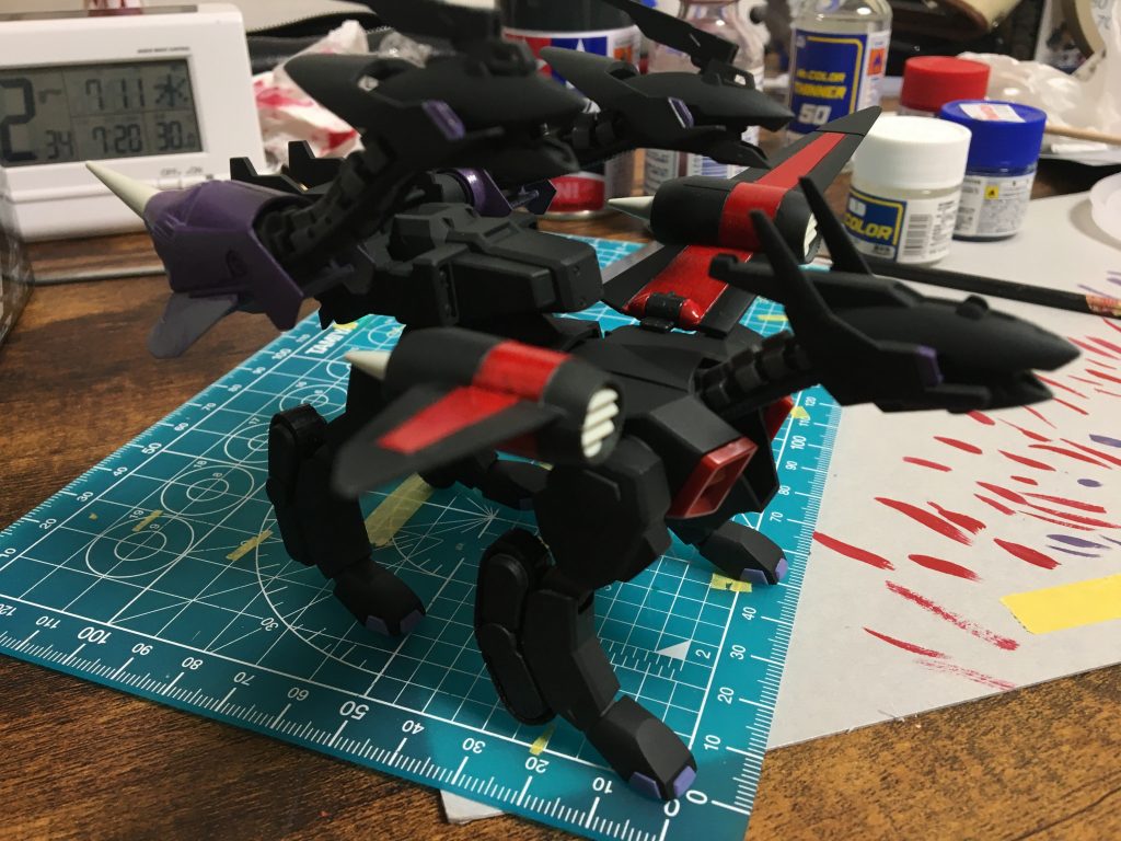 キャタピラーや関節部分にマスキングしつつ、全パーツにサフ吹き→本体だけにNATOブラック。
その後、本体の赤と紫、ケルベロスウィザードの紫とNATOブラックを筆で塗りました。赤と紫は下地に白を塗っています。
最後に赤とシルバーを爪楊枝で点づけし、額のカメラ部分に青竹色を塗ってから、
墨入れ→デカール→コートで完成です。
