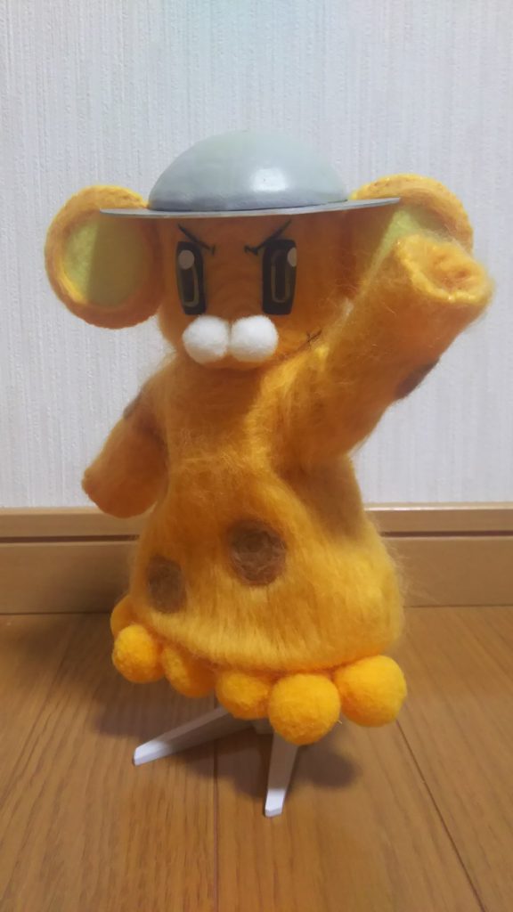 着ぐるみ部分のインパクトが大きいですが、一番苦労したのは
「目」です。100均で売っている透明なネイルチップに透明な
レジン液を流し込んで固め、裏側から黒→金→黒と多段階で塗装。
表面にハイライトを入れ、奥行と立体感を出しています。
（両目３セット制作し、一番マシなのを使用していますが…）
手部分には磁石を仕込んであるので、マジックハンド方式で
様々な武器を保持することが出来ます。