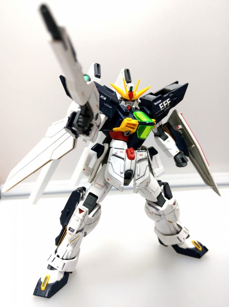 新地球連邦軍の力の象徴として開発された新型ガンダムタイプMS。MS単機としては究極的な攻撃力を持つ。機体製造は諜報統括官アイムザット・カートラル主導の下、太平洋上に建設された人工島ゾンダーエプタ島にて行われた。