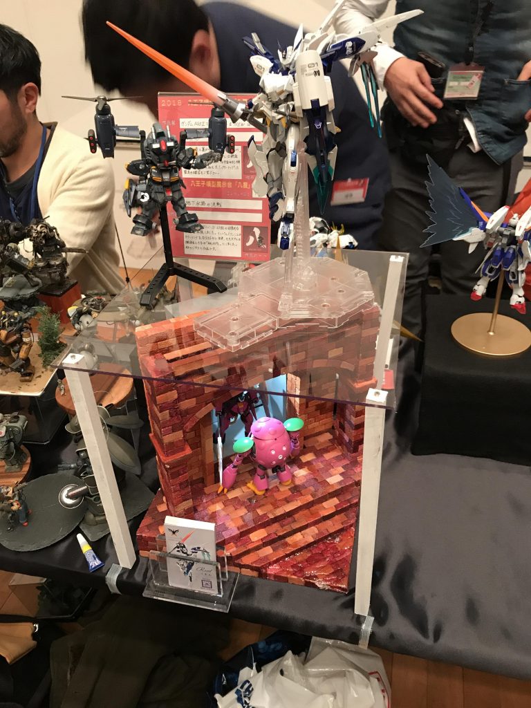 2019年1月開催の「八展」で展示した様子です。この時は原作カラーのモモカプルが間に合わず、それ以前に制作した「桃カプル」で代用しています。上空にAGEⅡマグナム改造機とGMを配置し、「ビルドダイバーズ」揃えにしてみました。
https://gumpla.jp/hg/97601