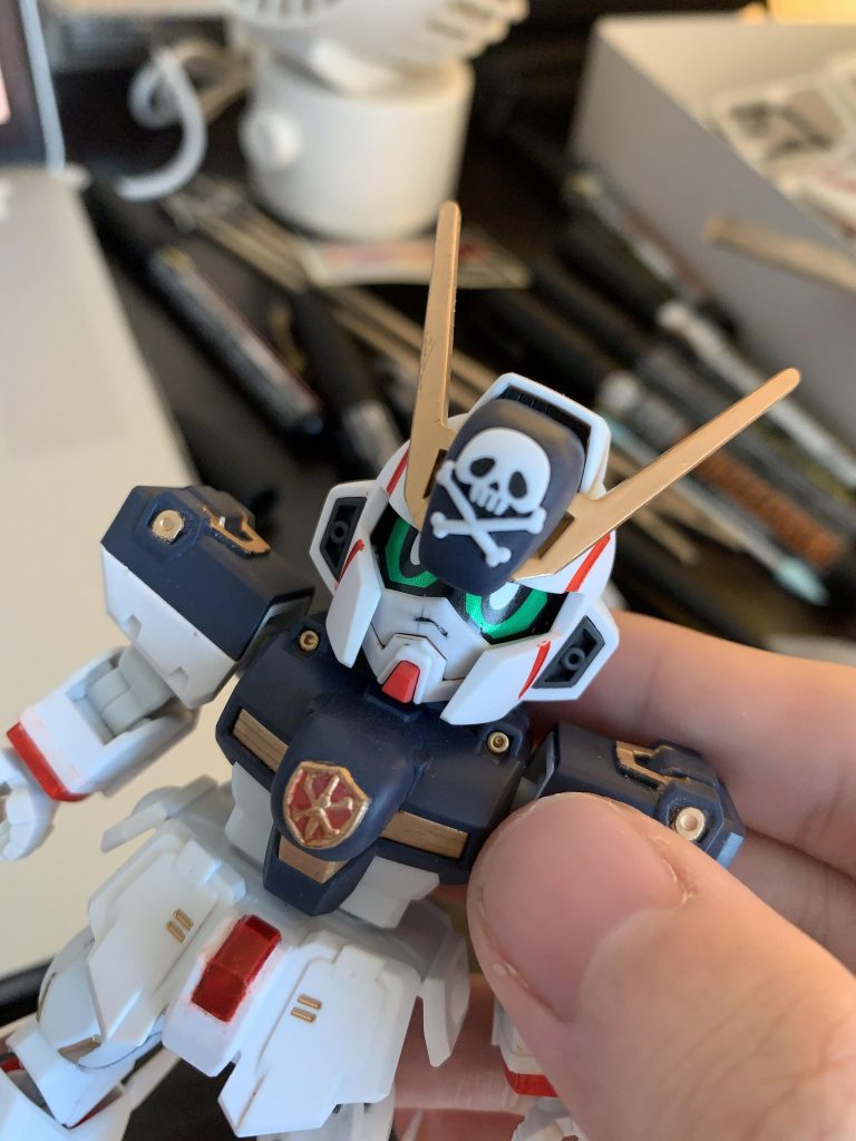 部分塗装した部分は:
まず黄色のパーツ、色分けされてないどころを全部つやけし金で塗装した。
使用したのは全部ガンダムマーカーです。
胸のクロスボーン・バンガードマークは筆塗りで大変だった。
今回で一番難しい部分かな。
手、アーマー、顔の赤も塗装した。
結構でかいなのに色分けされてないのが残念ポイント。