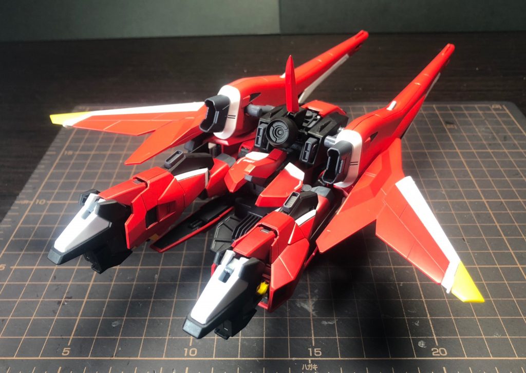 スケール違いの大型主砲が前面にくるため、かなり迫力のある飛行形態になりました。(でかすぎて撮影スペースに入りきらなかったため作業スペースで撮影しています。)
ほとんどの部分は本家の変形と同じですが、脚部の変形機構には変更を加えています。
本家では膝関節を折りたたむだけの寝そべり変形でしたが、今作ではZガンダム系の股関節展開ギミックを搭載しています。
これにより飛行形態時にビーム砲の砲身と折りたたんだ脚部が一直線に並ぶ形状となります。(変形後のA-Zガンダムのような感じです)
この股関節の展開機構も含め、MS⇔MAの完全変形が可能になっています。