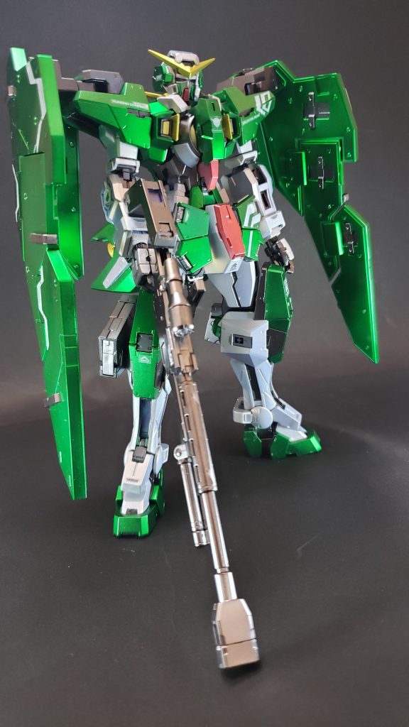 正面1
GNフルシールド
両肩アタッチメントに追加装備される外套状の大型GNシールド。片方のシールドにつき2段階のヒンジを持ち、アタッチメントの可動部を含めて装甲板を3段階に開閉させることができる。なお、防御時のシールド制御はハロが行うため、ロックオンは狙撃に集中することが可能となっている[55]。装甲材質そのものはEカーボンであるが、適切な防御角度を調節することができる