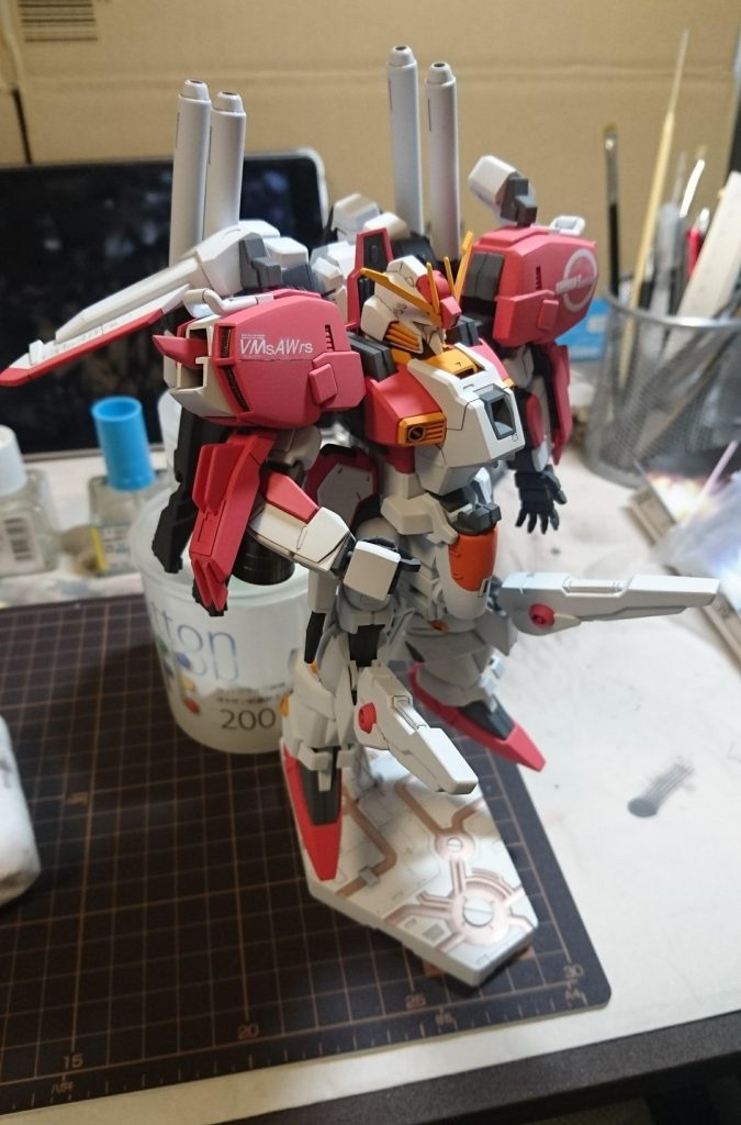 組み上げて立たせたら後ろにひっくり返ったので、慌ててベーススタンドに固定している途中。
ベーススタンド付属の両面テープがさらっと剥がれてしまい、固定ビスも全く噛まなくなったので、タミヤセメントでガチガチに固定。
テールバインダーの先端を、後ろから支えて安静にしていますw
仮組みした時は立ったのに…。