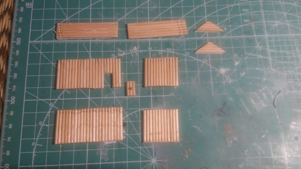 作りたい建物の大きさに合わせて工作用紙を切り、工作用紙の上につまようじを接着します。
(今回は、扉が開いてるようにするので壁と別に扉を作成しました。)