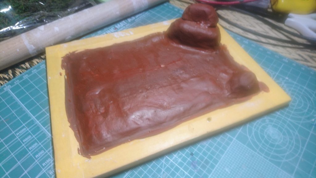 写真立て(サイズ2L判)に石粉粘土を乗せ麺棒で伸ばし、余った粘土で地形を作り乾燥させます。
茶色の絵具と黒色の絵具を混ぜ暗めの茶色を作り、塗っていきます。
(この時に写真立ての縁にマスキングを貼っておくと縁が汚れずに済みます。)