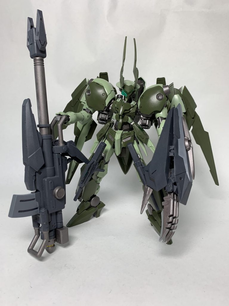 メイン武装のGNグランチャー(グラインドランチャー)
GNフィジカルバズーカから発展させた実弾兵器。
ランチャー自体に小型のGNドライヴを備え
、弾速と貫通性を向上させている。
弾頭である徹甲弾をGNフィールドでコーティングすることにより、攻撃対象の特殊フィールドや特殊装甲の類を貫通し、確実にダメージを与えることを目的としている。
弾頭は着弾するとGN粒子を噴出して目標を内部から破壊する。