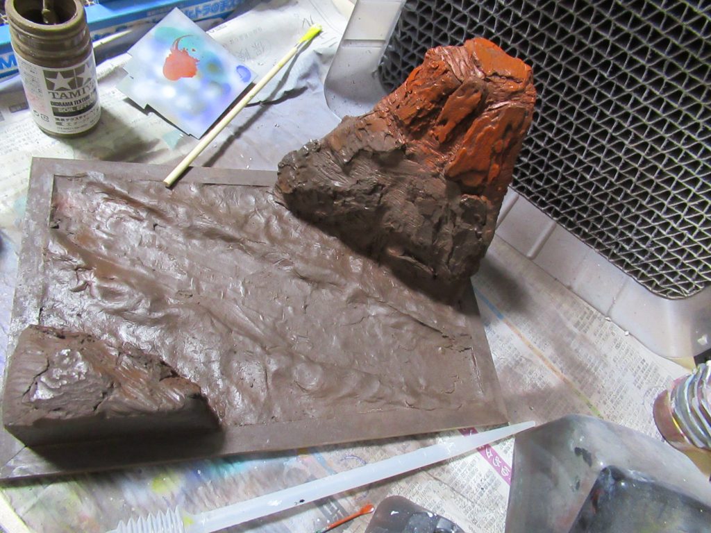 途中の写真を撮っていなかったので、色を塗ったものから。
額縁をベースにし、発砲スチロールで大雑把な岩肌の造形を作り、バークチップ、石粉ねんどを貼り付けて岩肌を表現しました。