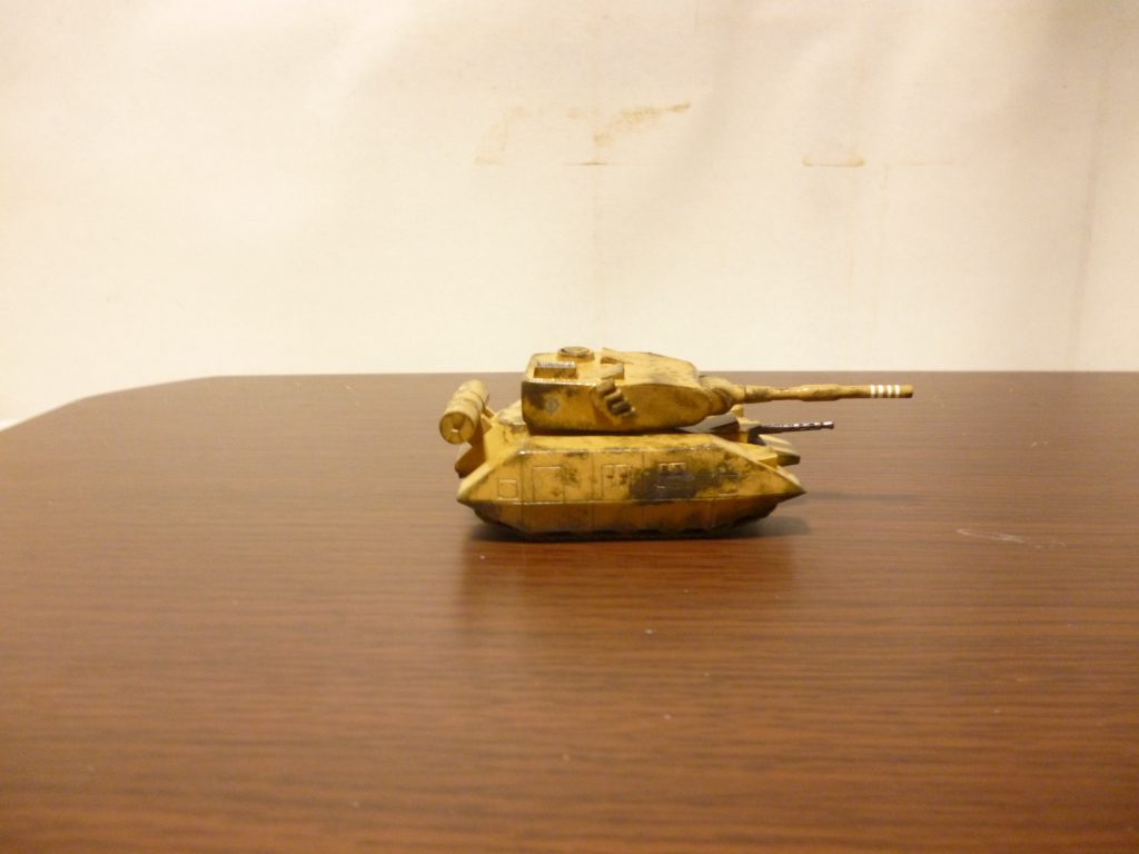 両側面からの画像です。
左側面(上画像)には、元にした画像にも見られる搭乗用と思しきはしごを、右側面には、こちらも元画像で確認できるスモークディスチャージャーを取り付けてあります。ちなみにこちらのスモークディスチャージャーは、プラ板とランナーによるスクラッチです。
また、左側面には部隊番号(15)、右側面にはジオンマークのデカールを貼り付け、さらにその上からスポンジチッピングによる「塗装はげ」を表現してみました。
それから、砲身の白いラインはマスキングによる手書きです。マゼラアタックの旧キットの箱絵を真似してみたのですが、このライン、一体何のために描いてあるんでしょう(撃墜マーク?)・・・?
ちなみに、今回はあえてデカール類は少なめにして仕上げました。モビルスーツや航空機ならともかく、戦車ってあまり注意書きがしてあるイメージがなかったので・・・。