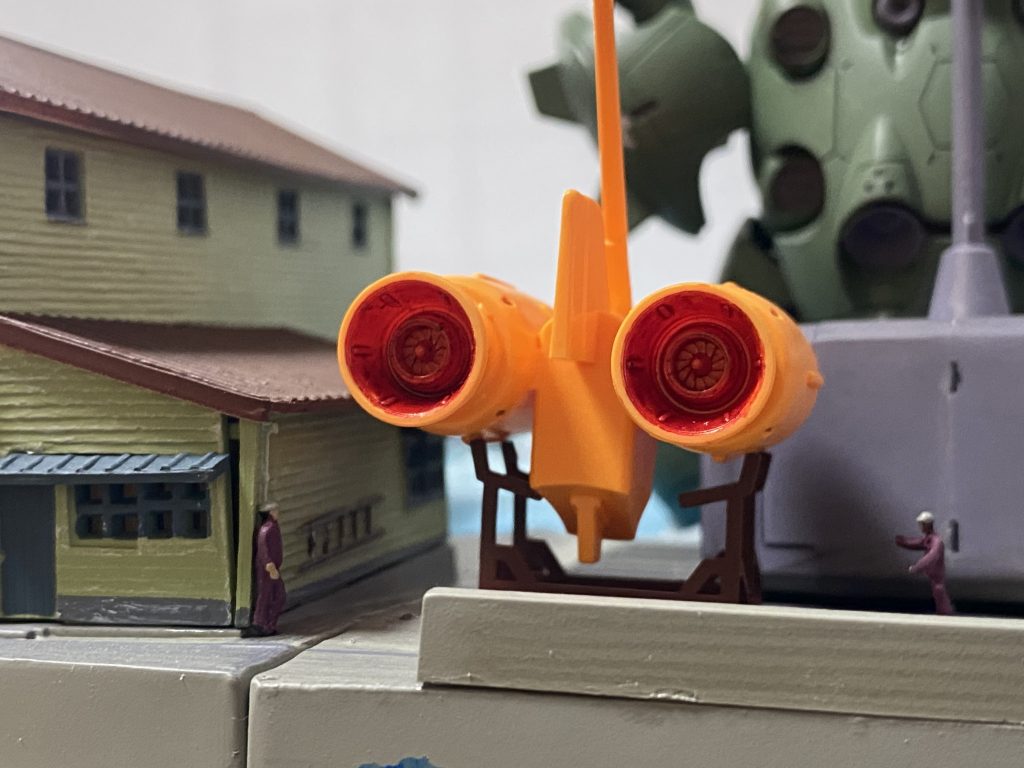 裏側では使われないブースターを背景にサボり兄ちゃんとそれを見つけた親方が駆け寄る一幕