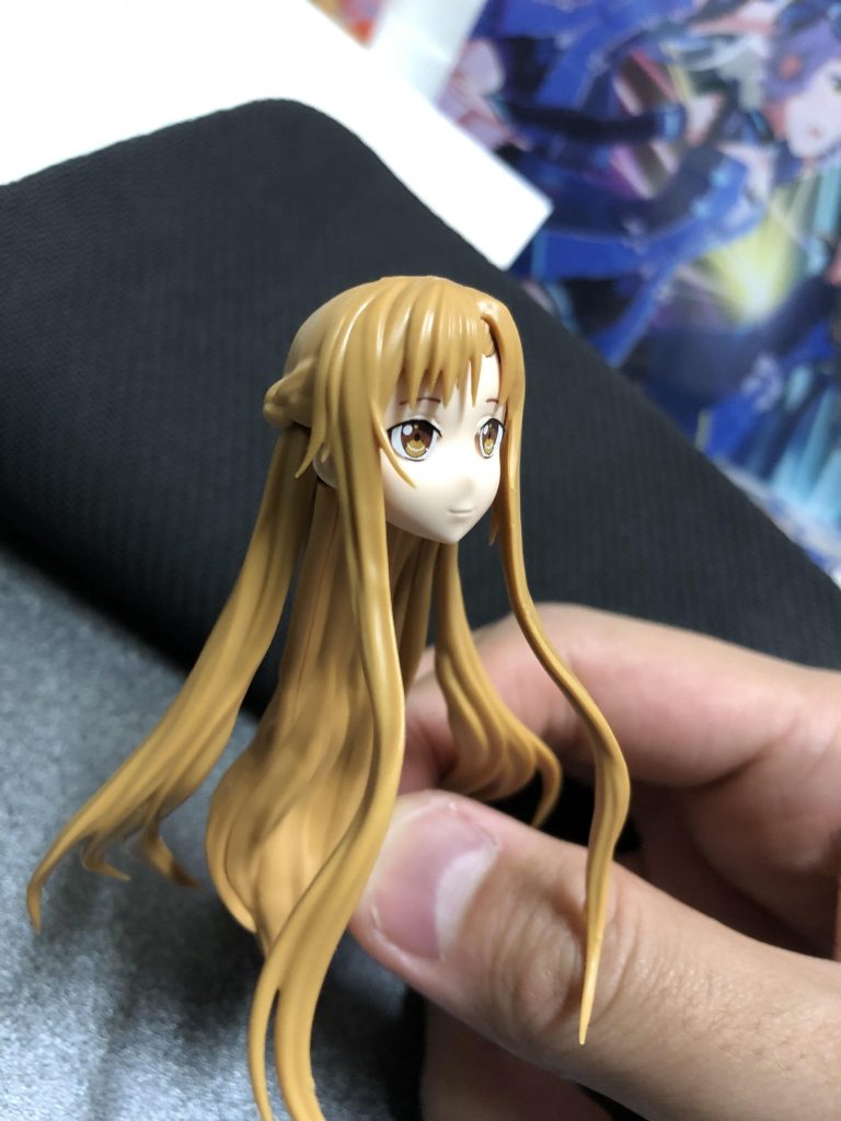 加工前のアスナさんの頭部です。この状態から
・もみあげカット
・前髪カット&パテで分け目のちょい毛追加
・後頭部編み込み部分カット&パテで整形
・切り飛ばしたもみあげの先端を使って、耳の下から肩の前にかかる毛を追加
等の工作を行い……