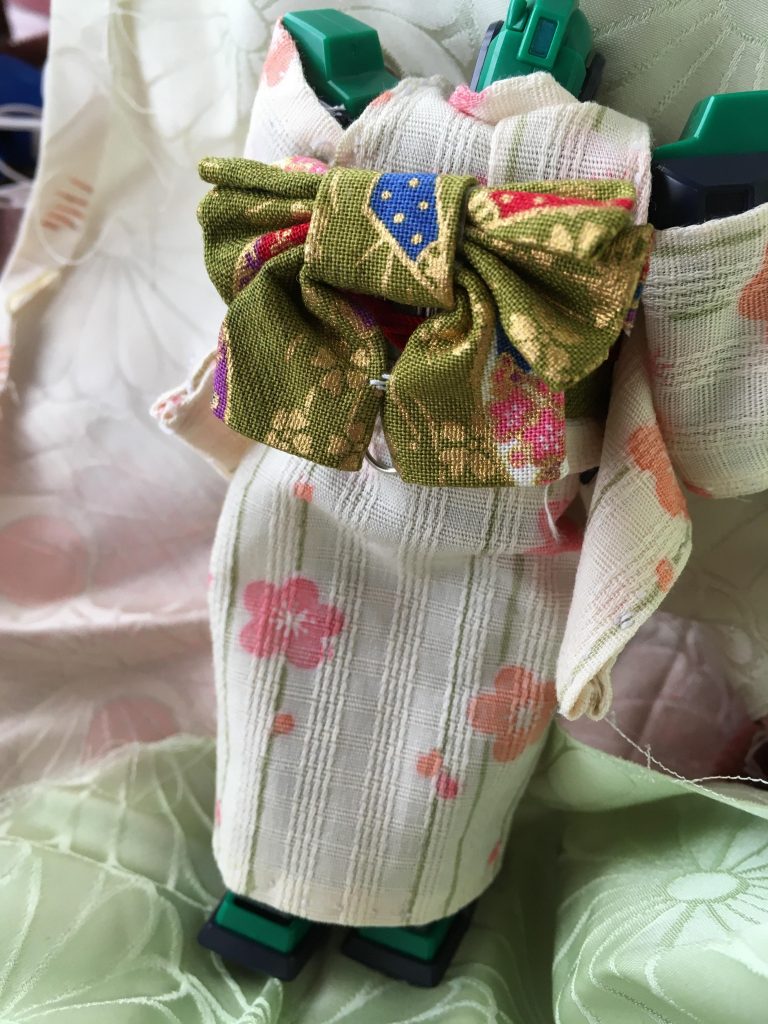 後ろはこんな感じ
帯は百均の和服の布を縫わずに両面テープを包むようにして作ってます
背中の帯の結び方は複数のリボン型のをまとめてくるんで、ゼムクリップつけて帯の隙間に差し込んで固定してます🖇