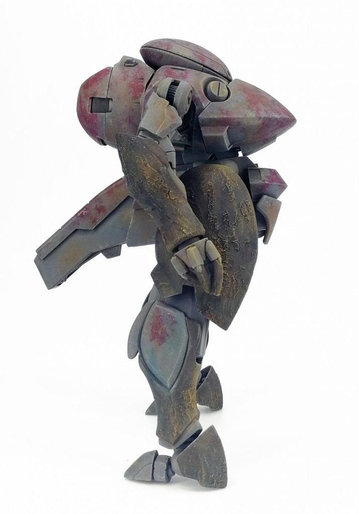 塗装は手足にシタデルテクスチャでひび割れたオロチの皮質部分をイメージした表面処理。
下地にメカサフヘヴィを塗って全体にドライブラシ、チッピングと軽いウォッシング。
一旦コートして本体部分の赤はファレホにAK236 ウォッシャブル添加剤を使用して派手に剥がしました。
さらにパステルやらの削り粉を荒めにまぶしてボロボロさをアップ。上からクリアでコートして定着させてます。
手足の茶色い部分は油絵具で青やオレンジの斑下地を作ってその上からガンダムマーカーリアルタッチブラウンで塗りつぶし。
濃いのに下地を隠さないインク系を活かす試み。
とはいえ思ったより下の色出なかったのでその上からさらに油絵具やパステルで処理してます。
フレーム部は通常の汚しに加えて菌糸の浸食度合いが強い部分に変色してるイメージで青を加えました。