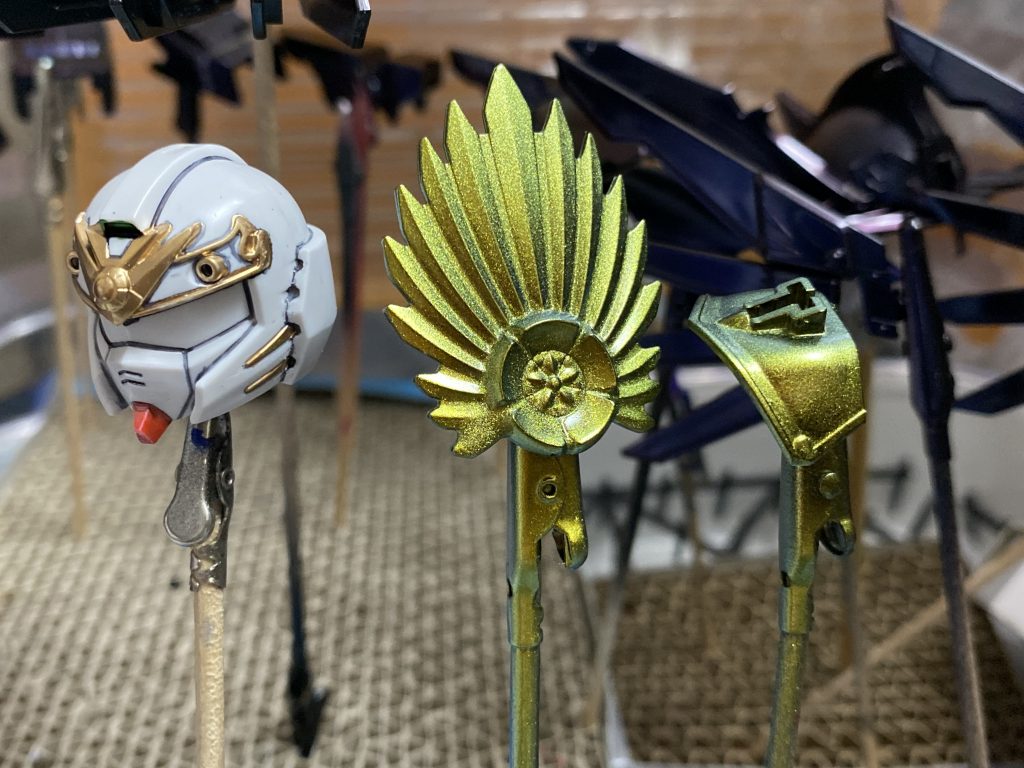 今回の塗装はガイアノーツのメタリックプリズム アズライトルビーを具足に、同社のメタリックプリズム ムーンゴールドシルバーを兜の前立てに使用。光の当て方で色の見え方が変わる面白い塗料なので、展示では映えるかな?と。
差し色やポイント塗装はガンダムマーカーアドバンスを筆塗りで。