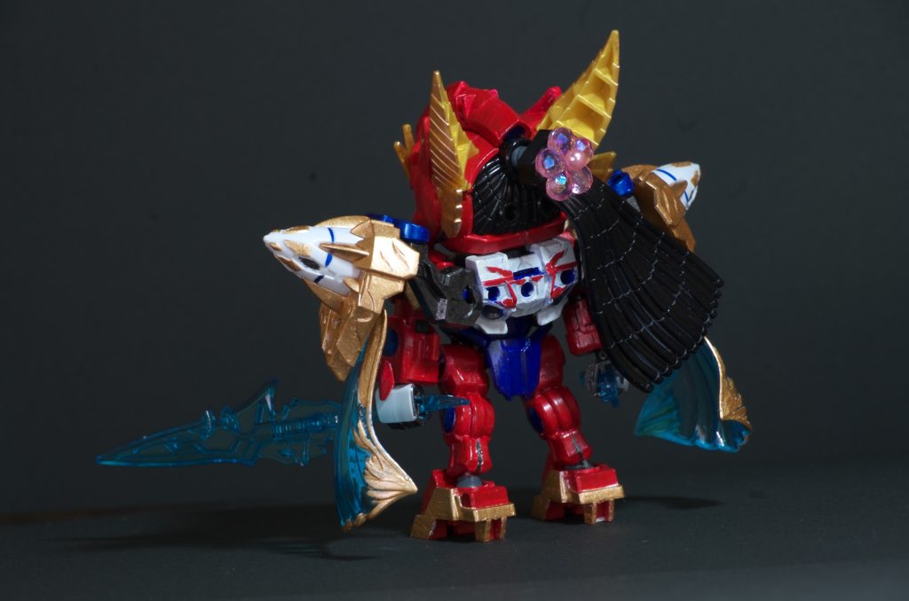 「趙雲ダブルオーガンダム」のアクアマリン色のマントが加藤真凛さんの特徴であるツインテールをイメージした装備と考え、バックパックごと移植。背中は白色に塗装して赤いラインを入れることで、2ndシングル「ガルスピ」の衣装っぽくしました。
ちょうどヴァルキランダーがポニーテールのような髪パーツを装備していたので、花の形のビーズを用意してビーズの中央をピンバイスで穴あけ、そこにパールカラーのまち針を通すことで花の髪飾りのついたポニーテール髪を再現しました。髪パーツとビーズはゼリー状の瞬間接着剤を隙間に練りこみ接着。