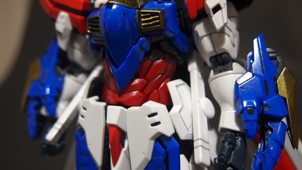 腰の前掛け部分を基部から2mmほどあげ、赤い腹パーツと腰の間にすきまがみえないようにし、胴長短足感を解消しました。両腕もモールドをけずりおとすぐらい補足し、直線的でシャープにしました。