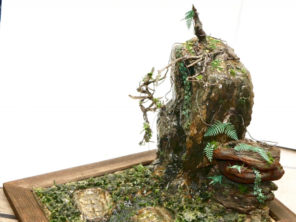 ベースは100均のフォトムレームを使用。
大きい崖はスチロール板を積層して、インテリアバークを表面に貼り付け。
地面は粘土をペタペタ、乾かないうちにキットの足裏を押し付けて足跡を作製。
まあ、キット置いたら見えないんですが。
あとはジオラマ用の市販グッズを適当に散りばめてます。
【キットの概要】