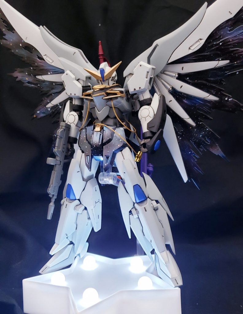 キャラクターの衣装再現の加工と光の翼の塗装に力をいれました。
改造の素体はテルティウムガンダムで、ボディの形状変更とバックパックの変更をしただけのお手軽改造となっています。
シンプルかつ魅力的にまとまっているテルティウムが灯織にピッタリだと考えて素体に選択しました。1人でも魅力的な灯織ですが、所属している3人ユニット「イルミネーションスターズ」のメンバー【八宮めぐる】と【櫻木真乃】と一緒になることでさらに魅力的になる…そんなイメージを改造に込めました。
今回の再現した風野灯織のゲーム中カードでは「星空に広がる白い翼」が印象的なアニメーションが入ります。それをプラモデルで再現するため,デスティニーの翼に白色の塗装、光の翼に星空の塗装を施しました。