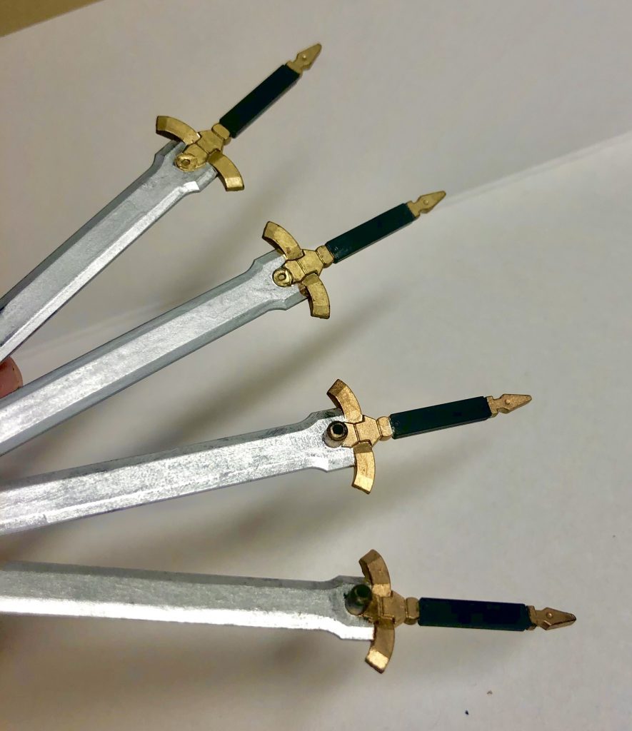 腰に懸架するピンが目立つので、大量にある剣の内マクギリス機にはピンをそのままにした懸架用2本とピンを切った手持ち用2本の計4本を割り当てました。

(上記の購入経路の都合で、こちらが塗装したものと、元の持ち主が塗装したものがあるため、塗装が別のものを使用しておりよく見ると色や艶が違います。)