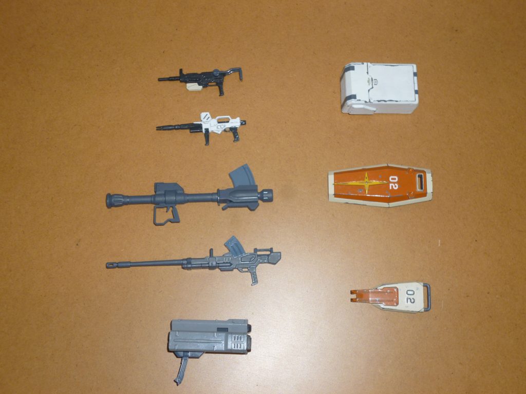 武装一式です。この陸戦型ジムのキット、HGUC顔負けの非常に豊富な武装が付属するお得なキットです。今回はさらに陸戦型ガンダムの武装も用意したので、これだけたくさん装備させられます。上から順番に・100mmマシンガン ・ウェポンコンテナ・ビームライフル ・シールド(ノーマルタイプ)・ロケットランチャー ・陸戦用ショートシールド・180mmキャノン・ミサイルランチャー陸戦型ガンダムからはビームライフルと180mmキャノン、ウェポンコンテナを流用しましたが、逆に言えばそれ以外の射撃兵装はすべて陸戦型ジムのキットに付属します(さらに言えば今回は使用していませんが、ジム・スナイパーにはロングレンジ・ビームライフルや1/1200アプサラスまで付属します!)。もうここまでくると、「モビルスーツのオマケ付き武器セット」ですね(笑)。