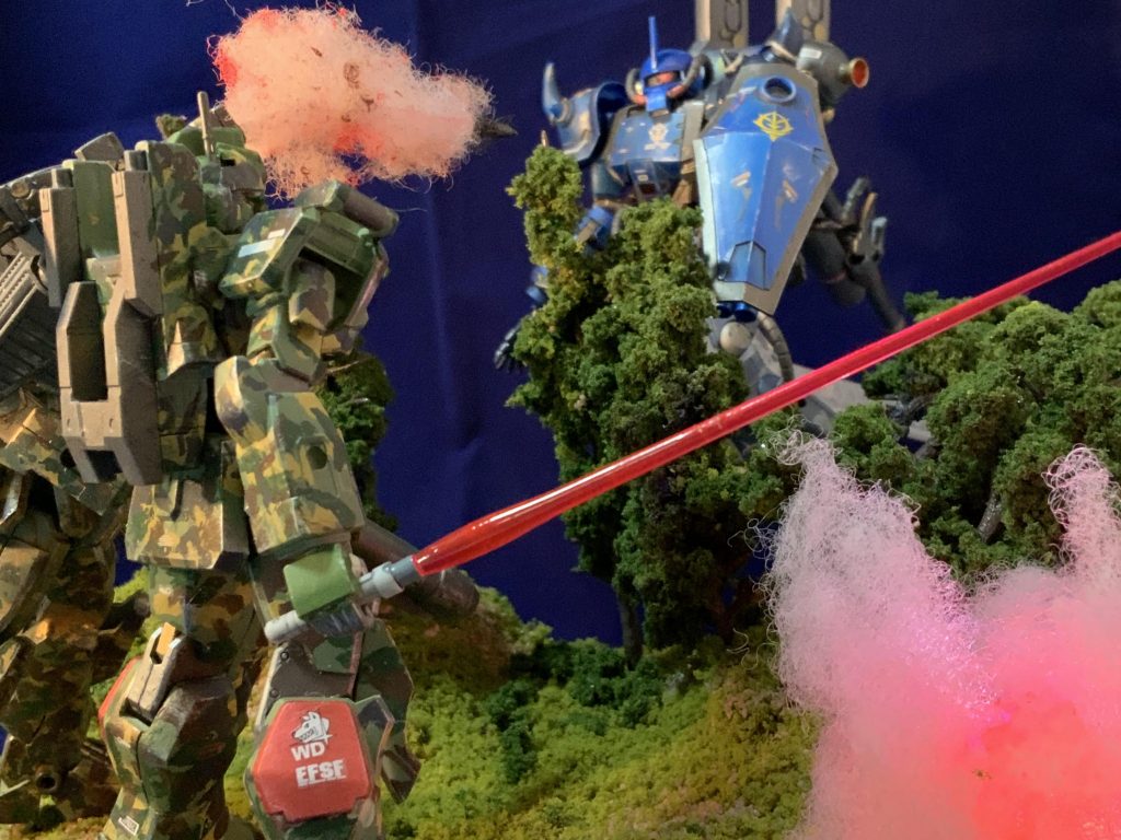 降下するさだきち大尉、ジム砂の攻撃はずれて地面に着弾