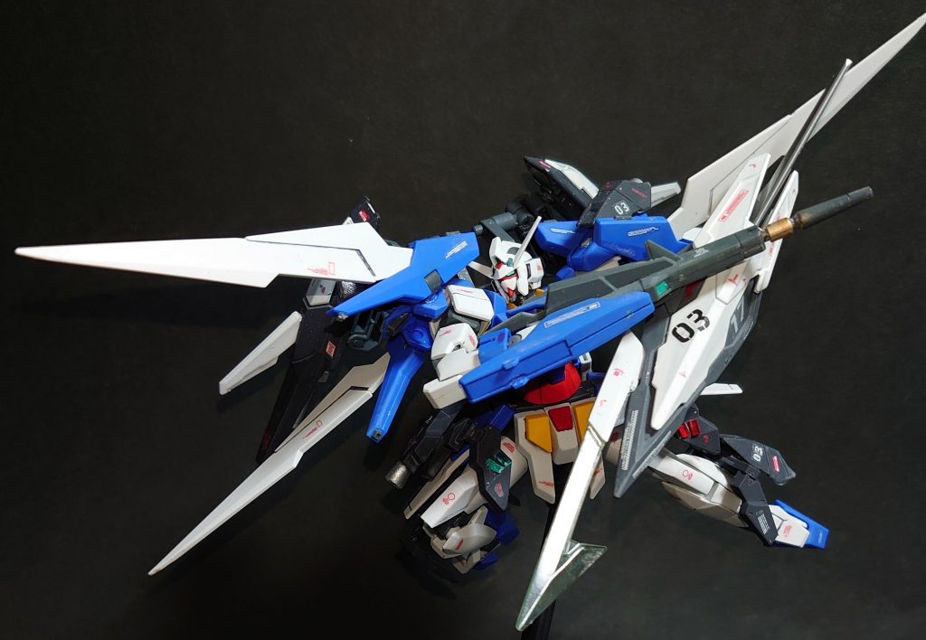 ## ・機体解説
*ガンダムＡＧＥ－２ノーマル FASTパック装備型*

ガンダムＡＧＥ－２は連邦軍としては初の可変機構を搭載し、高い広域運用能力を獲得した機体であったが、それ故に現行第二世代機との歩調の差に問題が生じていた。
これはＡＧＥ-２計画の最終段階であるクランシェの実戦配備おいて、大きな問題となることを意味していた。
そこで立案されたのが、MSに外付けの長距離航行ユニットを取り付けることで運用能力の拡大を図ったＦＡＳＴパックである。
その第一フェーズとして、唯一の現行第三世代機であるガンダムＡＧＥ－２でのデータ収集を行うべく本装備が開発された。

本装備はガンダムＡＧＥ－２ノーマルに追加の推進器兼増槽ユニットを装備することで、宇宙空間における機動性・航続距離の拡大を行い、ノーマルウェアの機能拡張を実現している。
装備面ではハイパードッズライフル用の追加センサーや多目的シールドなど、一対一の戦闘に特化した拡張が行われている。
これは単騎での包囲網突破をコンセプトに、火力による一対多の戦闘に特化したダブルバレットに対し、本装備が敵機との一騎打ちをコンセプトに、機動力による一点突破を想定した為である。

A.G.151年にアセム・アスノが本機と共に消息を絶ったことで、本装備の開発計画は一時凍結されることとなるが、ウェア換装ではなく外付け装備によって、あらゆる任務に対応させるというコンセプトはアデルマークⅡやジャケットシステム等、A.G.160年代のＭＳの運用思想に影響を与えることとなった。