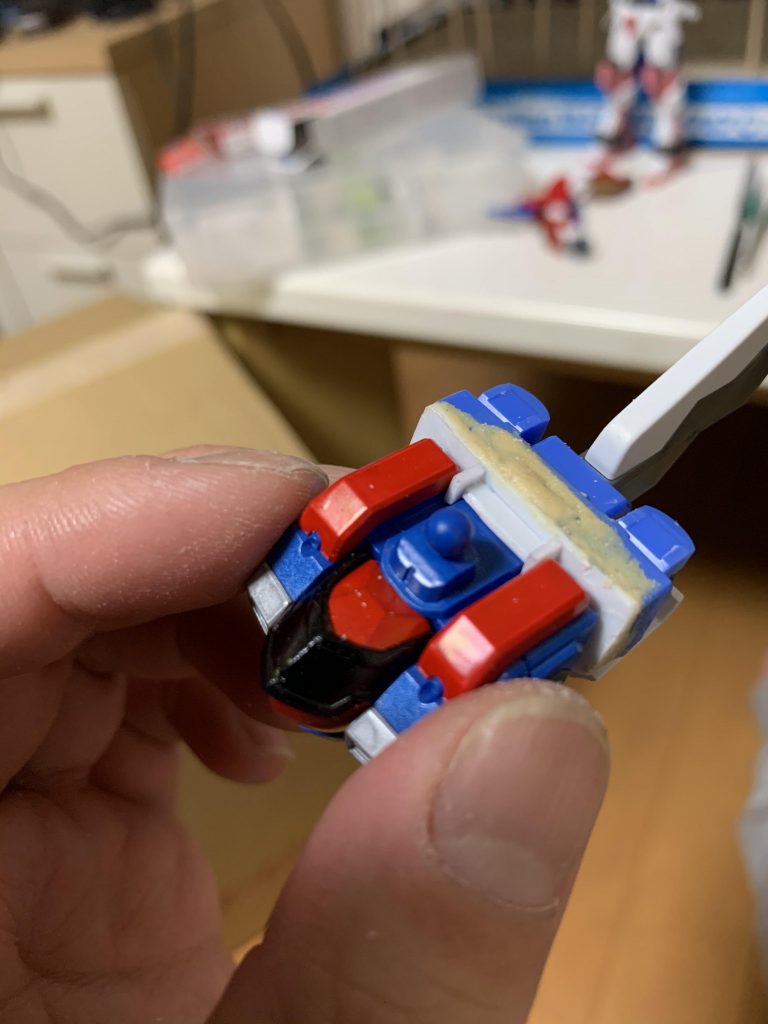 Hi-νのバックパックをかなり削り取り、穴を開けネオジム磁石を埋めこみプラ板で蓋をしました。
それだけだと心許ないので引っ掛ける爪をプラ板で切り出して取り付けました。磁石が1個だけだったので回転するのも抑えれましたり