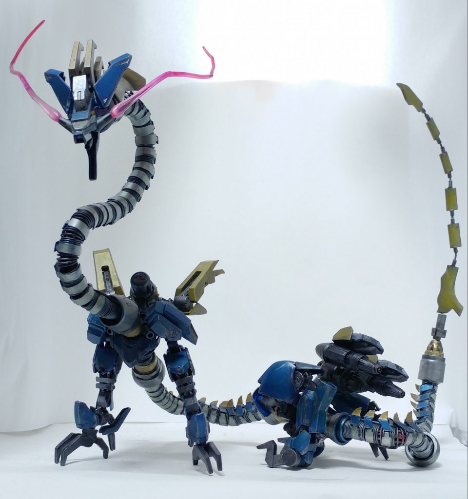 設定
*MA(モビルアーマー)　ザドキエル*

スペック
・全　　長　80.4m　
・本体重量　60.3t
・動 力 源　エイハブリアクター　大型×2　小型×3
・装甲素材　ナノラミネートアーマー
・武　　装　ビーム兵器(口部×1)　
　　　　　　前腕部クロー×2
　　　　　　2連装600mm滑腔砲×2
　　　　　　2連装120mm機関砲×2
　　　　　　超硬ワイヤーブレード

厄祭戦時に存在した東洋の龍に酷似した姿のMA。本体動力は小型のエイハブリアクターを使用し、*背部に2機搭載された大型エイハブリアクターにより発生した大量のエイハブ粒子を拡散させることで強力な疑似重力を地表と逆方向に発生させ、その反動で浮遊する。*この大型エイハブリアクターが発生させるエイハブウェーブは、*通常のエイハブウェーブよりも広範囲に無線機器やレーダーに影響を与える。*これを利用し、*自機の存在を隠すステルスのような機能を果たす。*首、胴、尾は超硬ワイヤーを主軸に、電磁コイルの役割を果たす人工筋肉に覆われている。これにより*自機が発する強力なエイハブウェーブの影響を受けにくい構造になっている。*
	
基本的な動作として高高度から人口密集地に接近し、ビーム兵器による広範囲攻撃、搭載された2連装滑腔砲や機関砲で爆撃する。そのため*地上に降りるタイミングはほぼ皆無に等しく、機関砲などの実弾を補給するためにごく稀に降下する程度である。*また、降下したタイミングで会敵した際は、*尾部に搭載された超硬ワイヤーブレードや前腕のクローでの接近戦の展開も可能。*
他のMAと異なる点は*無人機の生産を想定していないワンオフ機であり、ハシュマルなどの量産された他のMAを統率していたという報告例がある。*また、頬に特殊なビーム機関を搭載しており、直線だけでなく自由に折り曲げることも可能であった。*これは他のMAと一線を画す存在、または司令塔となるための機能と考えられている*が現時点では不明。
しかし、耐久性は低く、背部の大型リアクターが何よりも本機の弱点である。また、ビーム兵器を使用する際はリアクターに負荷がかかるため、自機の浮遊する高度を下げる必要がある。人類側はザドキエルが襲撃した際に何とか地上戦に持ち込み、多くの犠牲を払いながらも背部のリアクターから本体を切り離したことで辛くも勝利している。