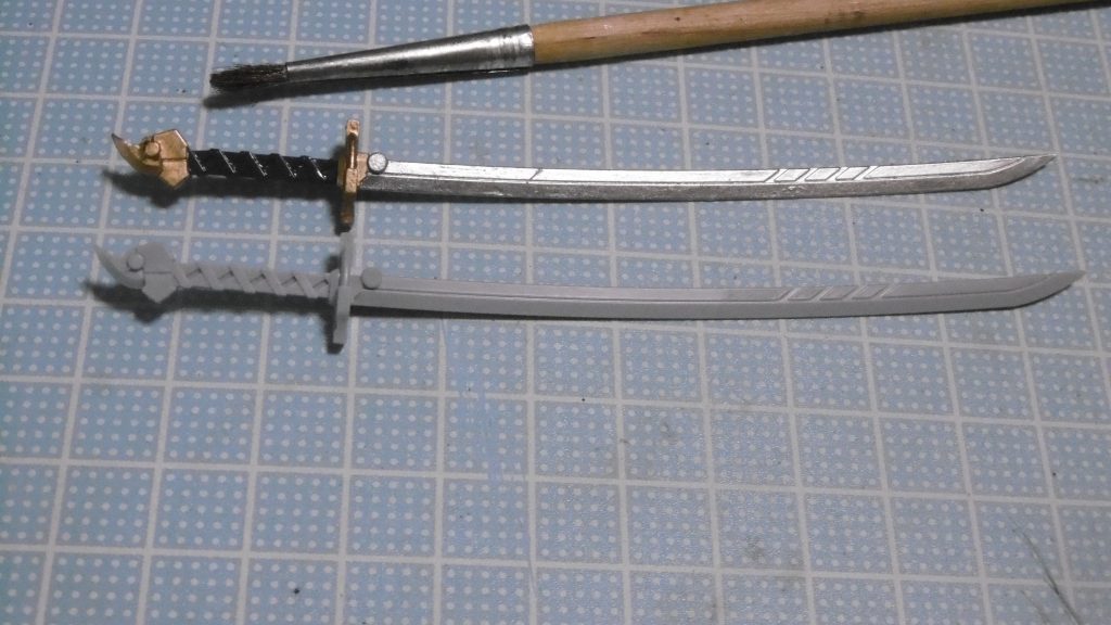 刀はビルダーズパーツHDのアレ。下の刀が未塗装参考用。
やっぱり筆だと塗り分けが大変でしたね。いつも通りの*マスキング無し*なので雑な箇所もありますが、マスキングテープを使わなくなった分大幅に時間短縮できました。
鞘の方は塗装後に取り付けたらジョイント基部が折れ、応急処置で瞬着。再破損を恐れて鞘の角度調整が出来なくなったのは内緒。