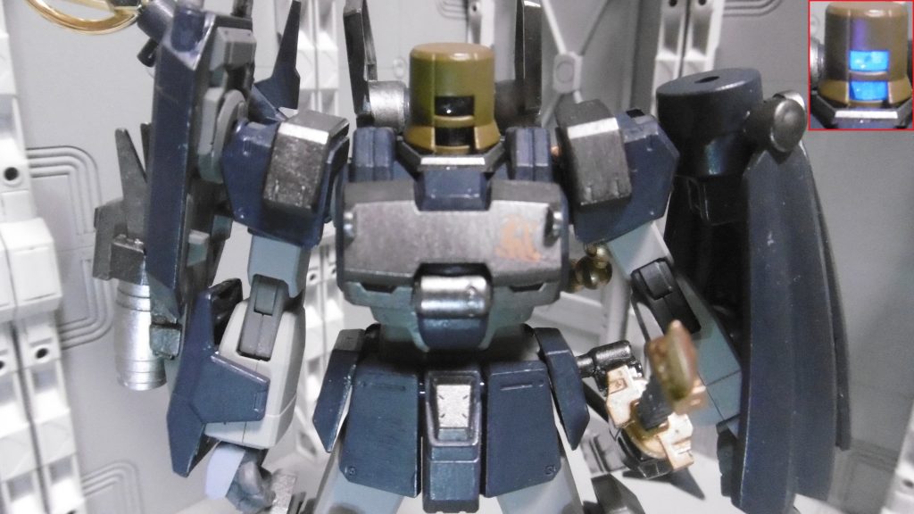 リーオーNPDバケツ頭が*虚無僧の深編笠に見えたのが全ての始まり*。
頭部センサーが透明でもブラックライト反応するように(例の塗料)
左肩のマントは風来坊が着用するような外套を意識。ノーネイムが発表されるずっと前からあった構想なので、躊躇せず盛り込みました。
サイドアーマーはパワードジムカーディガン(余剰含む)の物に変え、左腰に帯刀させています。