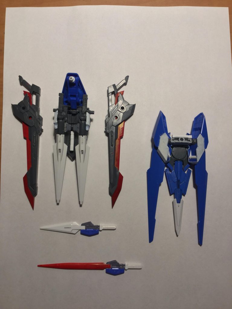 武装紹介(写真下から)GNロングブレイド改;エクシアのGNロングブレイドをベースに、刃のスリム化によりさらに取り回しと刺突時の使い勝手が良くなり、また特殊塗料をコーティングすることで赤く染まった刀身はGNソードV相当の切れ味を実現した。GNショートブレイド;エクシアのものと同一。GNロングブレイド改と連結してロンギヌスモードとなる。GNソードII;ダブルオーのものと同一。肩のバインダーユニットの向きを変えることで固定砲塔として使用可能。スーパーGNソードII;左ドライヴ部に装着。こちらはライフルとしての機能を廃し、追加バーニアとして用いられるが刃先の射出機構は残っている。トランザムGNブレイド;アメイジングエクシアのものと同一。改修以前は背部にマウントされていたが、本改修後は左肩に移動、機動翼としても使われる。エグゼガンブレード;その名の通り銃としても剣としても使える。マウント状態では回転砲塔として機能する。また、メインパーツをパージすると狭所戦闘用の小型銃剣になる。左右ドライヴ部隠しビームサーベル;RX-0系と同一の形状。非常時に使われる。普段は各種装備に隠れてほとんど見えない。右バインダー基部はエグゼニスウイングとダブルオーのドライヴ、ビルドブースターに付属するジョイントを使用しています。