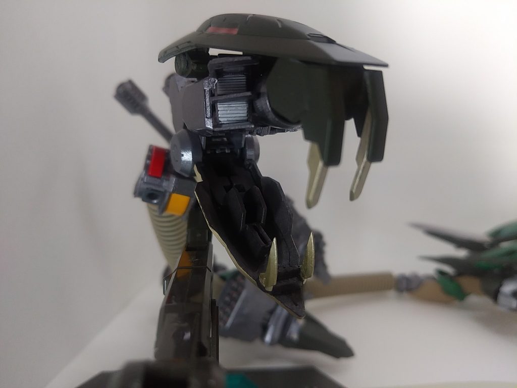 頭部はほぼレギンレイズジュリアのパーツで作っています。頭はリアスカート。上顎の牙は駐機状態の足。下顎から首まではレギンレイズ足首から延長された脚部を使ってます。下顎の牙はMSGカスタマイズヘッドCの牙を加工して使ってます。