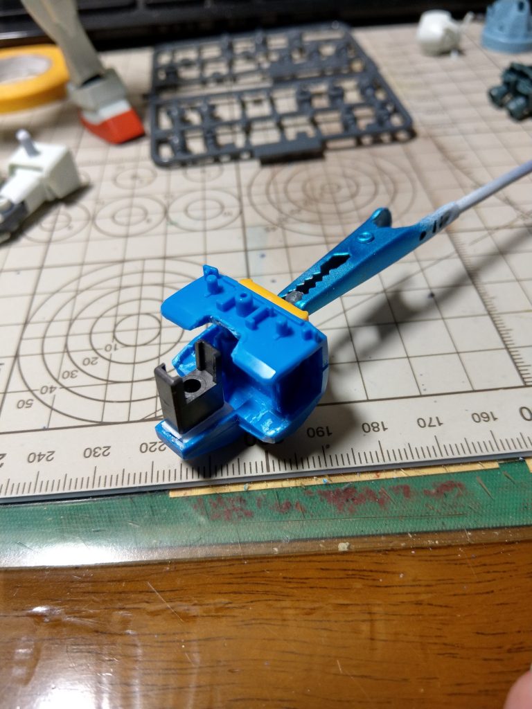 あとは上半身。とにかく削ります。イージスの腕の内側の赤いパーツが入るようになるまでひたすら削ります。それが終わったら胸の中央に蓋をし(今回は1mmプラ板2枚)、ピンを切り落としたイージスのパーツを貼り付け。
ここはピンを切り落としたりせず、蓋側に受け穴を作って接続で良かったなと後で気づきました。
最後に嵌め込み易い用に背中中央を少しだけカット。
あと写真撮ってませんでしたが、奥に映ってる腕の接続、ボールジョイントから3mm軸に変更してあります。