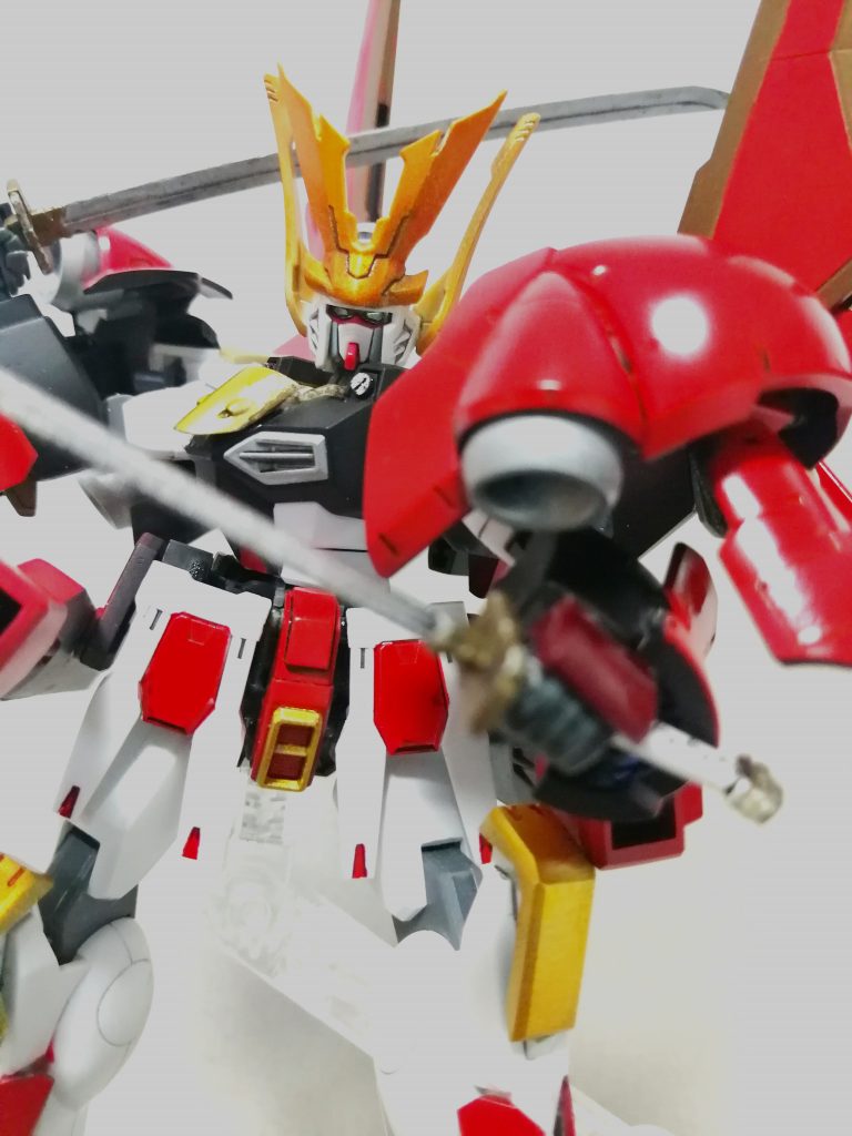 「メインカラーを赤く塗って、あとゴールドを差し色にしたら脳が勝手に武者っぽく理解してくれるはず」という浅はかな考えで塗り始めたので、よくあるカラーリングになってしまったかも。ゴールドは、・ガンマカゴールド吹いただけ(踝など)・シルバー吹いて上からクリアイエロー(胸アーマー)・シルバー吹いて上からクリアイエロー&クリアゴールド(軍配や前立て)を使い分けました。3つ目が見栄えしますね。全身・前面には装甲を増し増しにしているので高い対弾性を持つ上、大型バーニア追加による離脱能力も高められているので、戦場に置けるサバイバビリティが大幅に強化されています。
