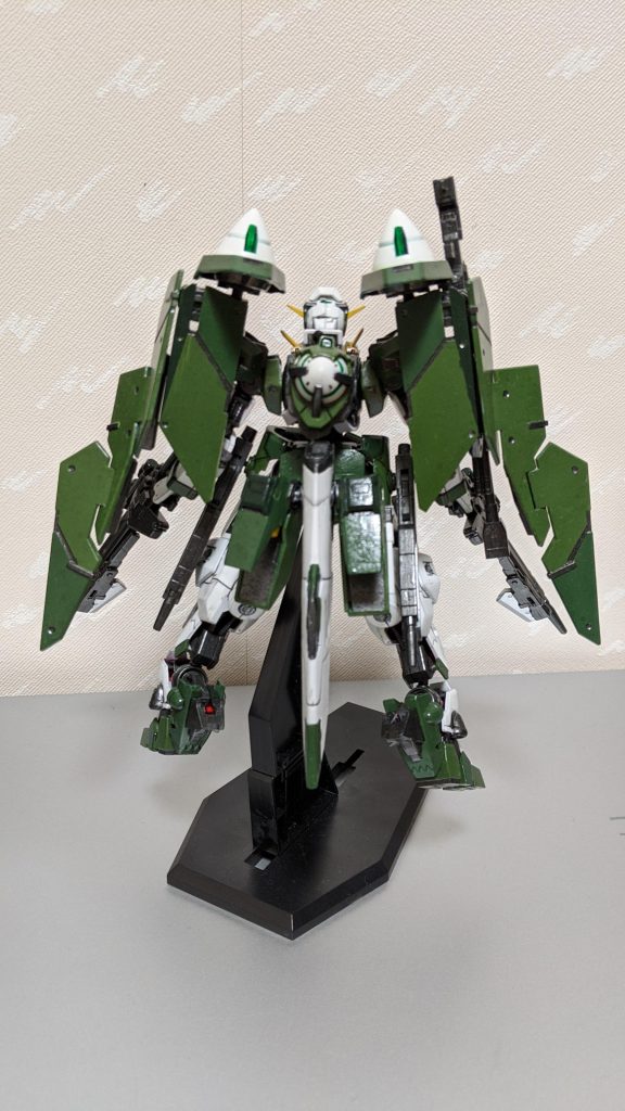 背面から。
トリプルドライブシステムを採用した最終決戦型。イオリアの計画において、GNT-0000のデータと共に保管されていた強化プラン。
他のマイスターも乗れるように、全てのガンダムシリーズの特徴をまとめた機体。
拡張性が広く、単機で行えるどの戦術でも対応している。
GNビットはこの形態の時、取り付けはできない。代わりにその他のライフルが全てハロの操作によって独立稼動できるようになっている。GN-010のプランがベースとなった。