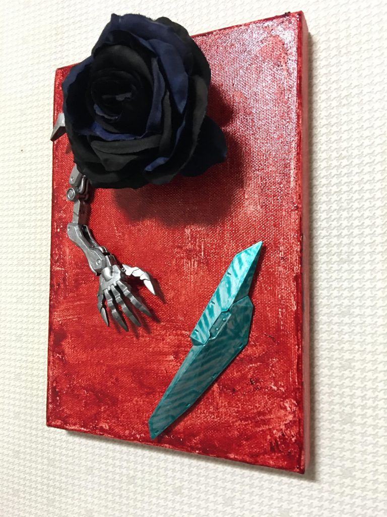 銀色の異形の腕の先にある抽象的な物体はゼルトザームのシールドです。こちらもシタデルカラーで筆塗りしています。筆ムラを逆手に取り、縞模様を描き、一色で表される他の造形との差別化を図りました。この辺りも、岡本太郎の初期の抽象画からヒントを得ています。また、メタリックなグリーンは背景の赤との対比でもあります。