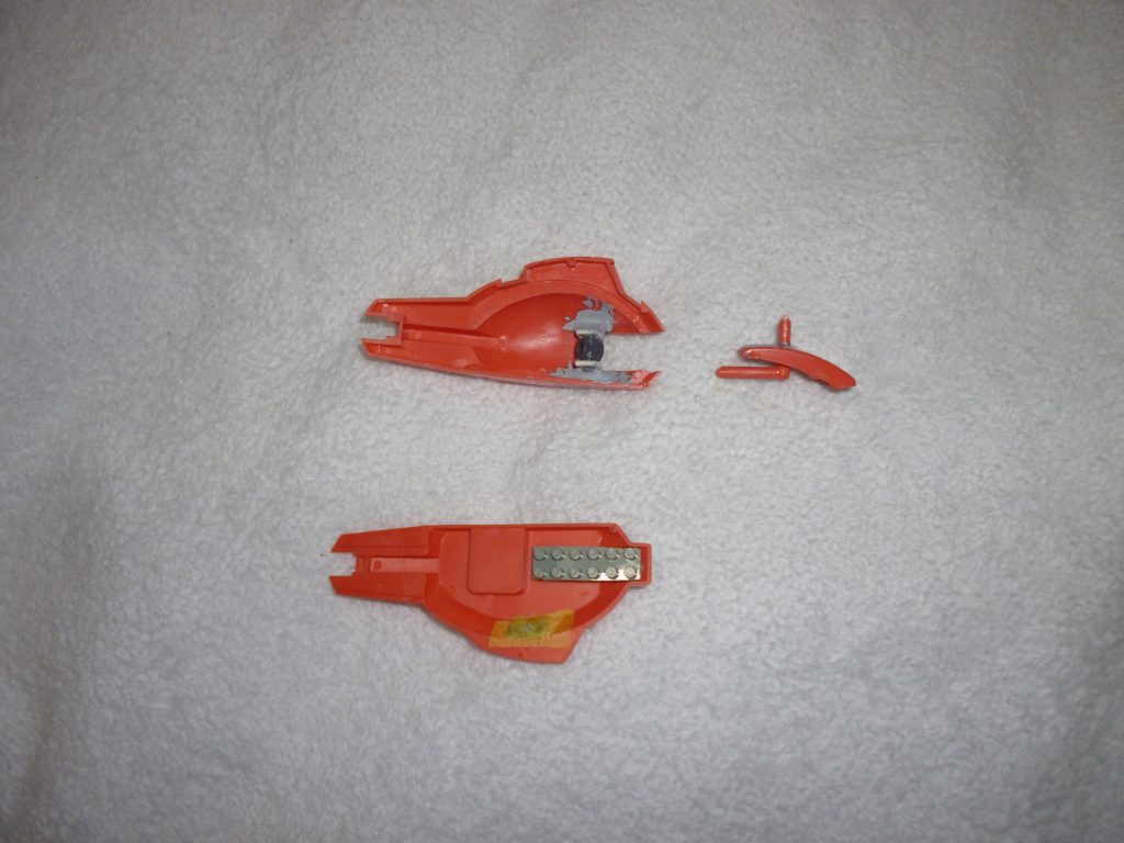 肩部バインダーです。
もともとは上下張り合わせのいわゆる「モナカ構造」だったのですが、ミサイルランチャーの部分を切り取り、ポリキャップとL字型のプラ棒(ランナーから切り取ってきました)で膝関節と同じ「スライド関節」を組み込みました。
ミサイル本体はレゴブロックをカッターノコで切り取って作りました。
塗料を買うため近所の家電量販店のおもちゃコーナーに立ち寄った際、たまたまレゴを見つけ「これだ!」と思って購入しました。
さらに、バインダー脇のビームサーベルは取り外しできるよう、裏からポリキャップのランナータグを張り付け(画像のマスキングテープの部分です)、ピンバイスで開口しました。