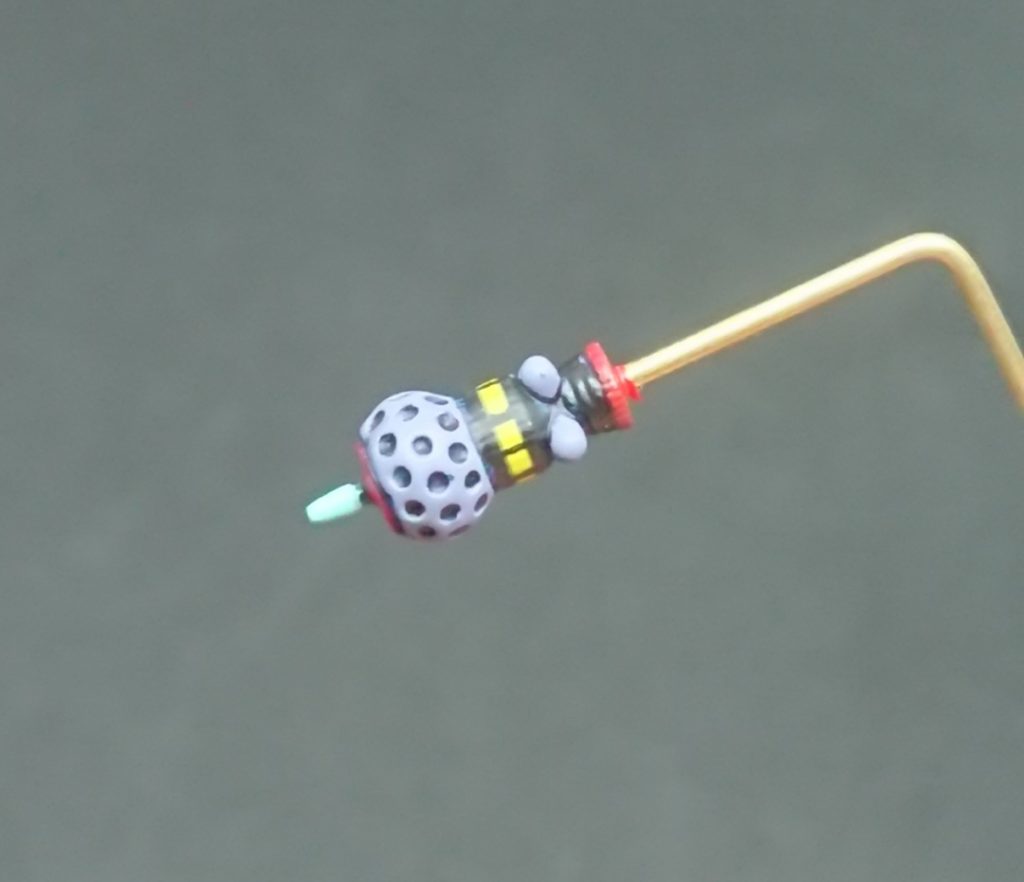 ビット本キットのラスボス。ゲート跡で潰れてる●ディテールを1mmのピンバイス復活させ、バーニア部分に持ち手や展示用の1mm穴を開口。ダグラムカラーのグレーバイオレットを吹き付けた後、タミヤエナメルのレッドを筆塗り。先端部にリニューアル版水性ホビーカラーペールグリーン筆塗り。黒い部分を同じくリニューアル版水性ホビーカラーのブラック筆塗り。はみ出したところは溶剤の種類の違いを生かして拭き取り。省略されている黄色いパーツの再現のために黄色いラインデカールを巻き付け、キットのディテールをなぞるようにスミイレ用のガンダムマーカー油性で線を引いて完成。…精度とかはそこまで拘らなくても良いかなって…