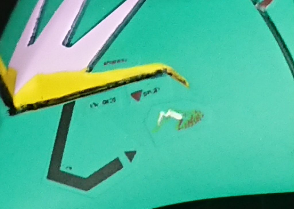 アップにすると荒が…MSVイラスト見ていると、目尻の辺りに明らかにコーションとは違うマーキングがあるんですよね。最初は光の反射や汚れの表現かと思いましたがどうも違う。アルファベットのMないし羽を広げた白い鳥の下に判読不可能な文字らしきもの…まさかエルメスかララァのエンブレムなのでは?と。MSVのイラスト以外に同種のマーキングが見当たらないので想像で補完し、Mを大きく書いたMANー08、もしくはララァの好みで白鳥と解釈し、両方の図案を作りましたが、前者がいまいちだったので後者を採用。文字は恐らくパイロット名であろうと考え「Lalah」としました。ただ白は印刷できないのでデカールにはアウトラインのみ印刷し、極細面相筆でエイ!ヤア!とエナメル塗料で描きました…MSVイラストとはなんかバランス違っちゃいましたがしょうがない