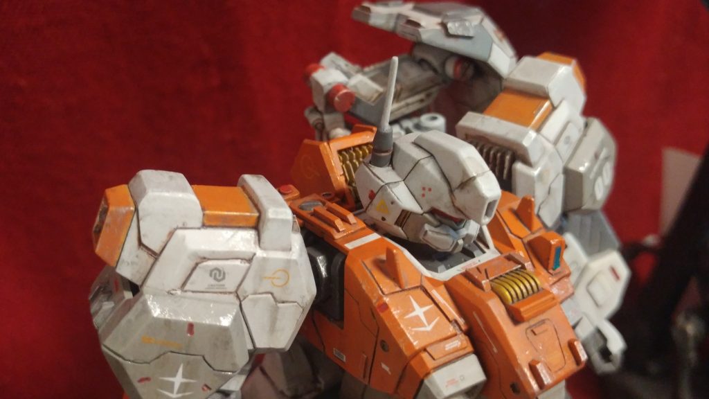 大きな特徴でもある、左右非対称なVアンテナを敢えて廃し、メインカメラ基部はフラットな形にして、ロッドアンテナを右後頭部に配置することにより、「量産機感」を演出してみました。また、肩アーマーも一部形状変更しています。左胸にはサーチライトを追加してあります。胸のダクト(白い部分)は、元のままだとなんだか突出乳首みたいに見えてしまうので(失礼!💦)、スジ彫りと塗り分けで小さく見えるようにしました。