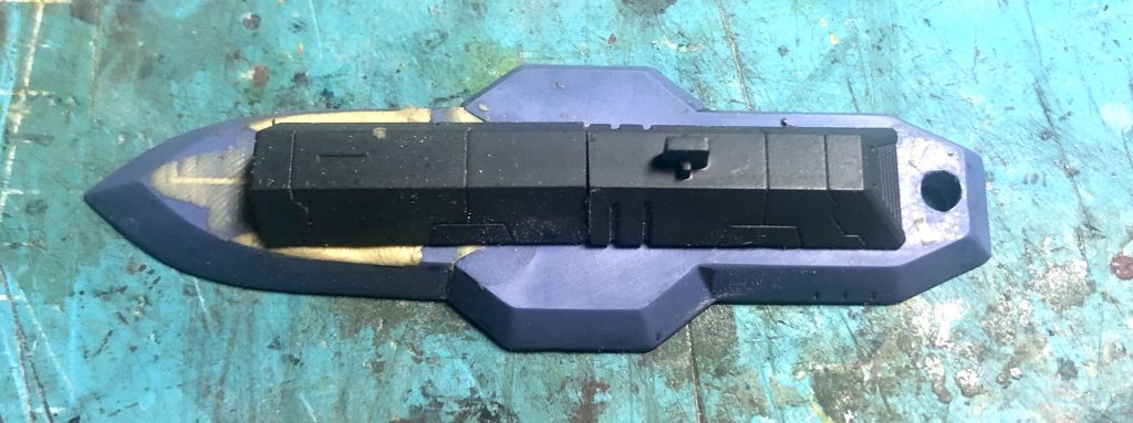 バインダー表面の凸モールドなどをヤスリで均し、凹モールドなどをパテで埋め、ダインスレイヴ の銃身を表側に間を8mmほど詰めて接着しました。
(画像はパテの形成と塗装前の仮組みです)
この段階でバインダーの伸縮ギミックはオミットしました。