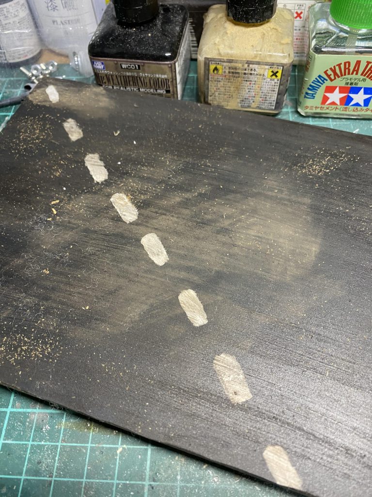 ヴィネット完成の1歩手前です!
プラ板にダイソーで売っていた漆喰を塗ってジャーマングレーで塗りました。その上に道路として白のライン、砂を表現するためにウォッシングとバラストをまいています!