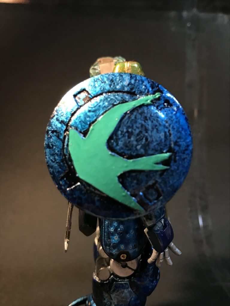 トールギスのシールドのエンブレムをパテで埋めて、プラ板でツバメのマークを入れました。
ツバメの意味は諸説ありますが、「家族への愛」という意味があったので、未だ再会出来ていない自分達の部隊に必ず帰るという意味を持たせたくて作りました。