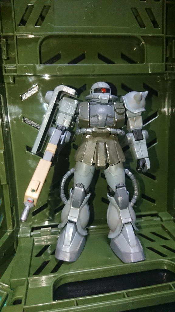 背景を100均のコンテナ使って、格納庫の雰囲気に。モノアイはHアイズをメタリックレッドで塗装。全塗装後、エナメル塗料のシルバーを使って、塗装剥げをイメージ。