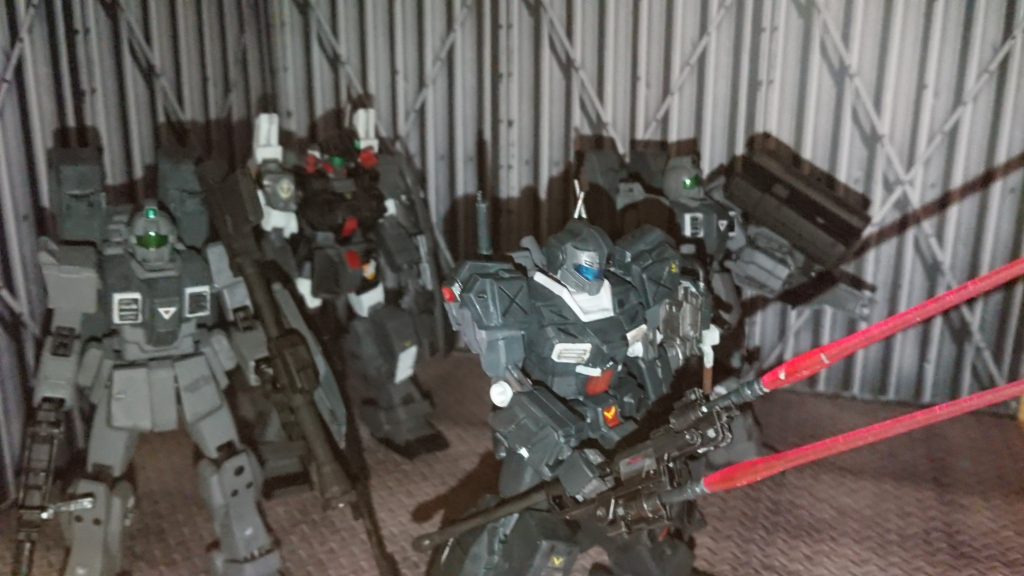 「……スレイヴレイスかい。ったく、汚れ仕事をする奴等の大半は犯罪者ってかい」
ジムストライカーを操縦しているパイロットが呟くと後方にからついてくる陸戦型ジムが二機がその話を耳にしながら「何処もそんなもんでしょう」と呟いていたのを無線越しで呟きながらも隊長機として配備された後方にいるジムスナイパーⅡのパイロットだけは操縦をオートで機体を歩かせながらも任務で引き受けた彼等の出所を確認し、それらの記録を目に通しこう呟く。
「……どうあれお上の命令だ。向こうはジオンとつるんでる証拠も抑えたというんだ。陸ジムの隊は奴等の部隊の撹乱として奴等のエンブレム使用での敵ピクシー撃破を勤めろ」
「ハハッ、敵が大物だけあって俺等はエサっすか」
「まぁ,隊長はエサを見捨てるようなヘマはしねぇから任せられるがな。だが……HLVの打ち上げで粘られてっからな。正規兵の奴等を無駄死させねぇのが任務ってとこですかい」
「……それも貴重な戦力だ。なるべくこっちでその正規部隊に忍んで仕留めさせてやろうじゃねぇか」
彼等はそう呟きながらも後に味方の部隊に紛れ込みつつピクシー1機とイフリートの撃破にスコアを挙げその後も暗躍部隊としてなりを潜めては敵や味方の怪しい動きを監視しつつ任務に忠実に従いながらも一年戦争どころかデラーズ紛争などにも暗躍して活躍することとなる。