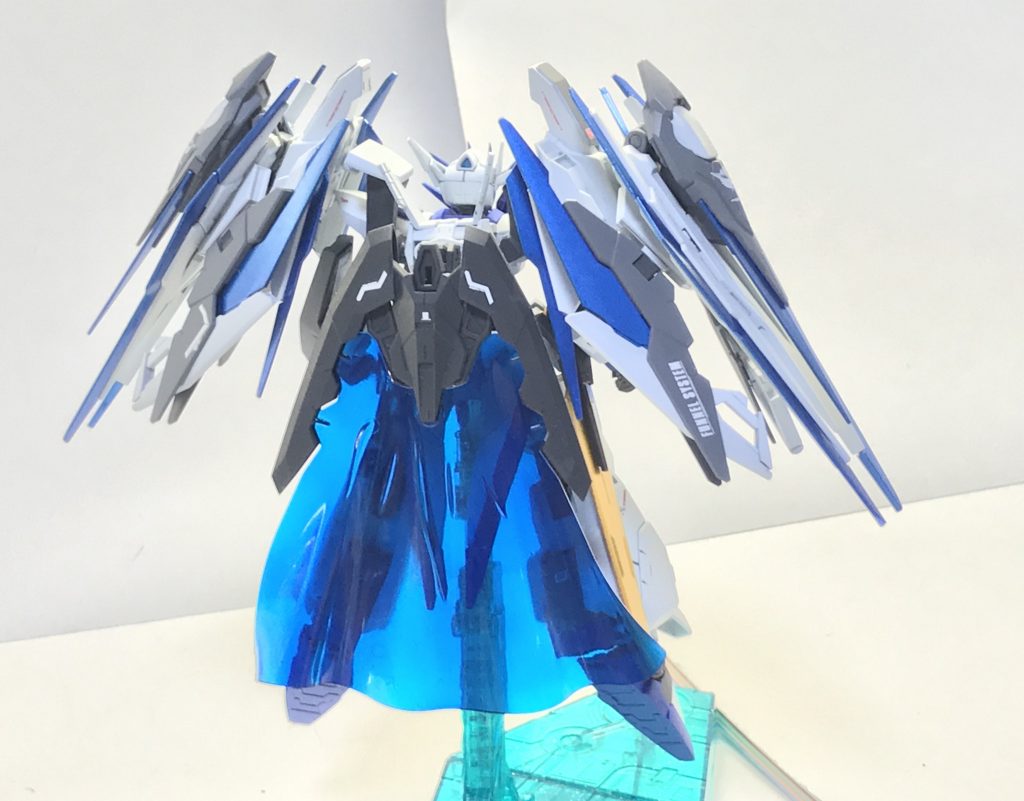 背面。背部にはトライエイジガンダムからコンバートされたトライフレームホルダーが装備されているが、現時点でGBNにおいて原型機のシステムを行使できるようになるパーフェクトレア報酬を保持しているのはチャンピオンただ一人であるため、本機の場合はGNドライヴの機能がなしえる範囲での機能しか行使することはできない。一応GNパーティクルマントを全身に巻きつけて突貫するといった芸当も可能だが、明確に不可能である「他の機体の武装や機体そのものの召喚」以外のどこまでが可能なのかはダイバー自身にもよくわかっていない。