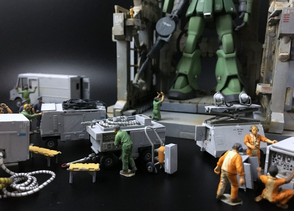 整備風景なのでクルーや機材も欲しいところですが、流石のガンプラにもそんな都合のいいものはありません。ここはあくまで「脇役」ということで、他社製品からエアーコンディショナーや投光器、油圧テストスタンドを持ってきました。