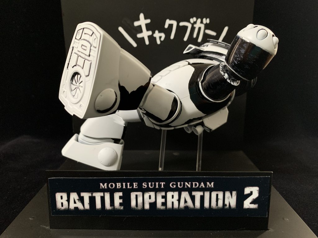 こちらはガンダムゲーム「バトルオペレーション2」のキャンペーンにてプレゼントされていたTシャツに描かれていた絵をガンプラで再現したものになります。ご存じない方にご説明しますと、こちらのゲームにはモビルスーツに部位耐久力が振られており、特に脚部にダメージが受け続けていると、ブースト移動したときに機体が支えきれなくなり転倒してしまう状態になってしまい、高速で後退しているときなんかは、写真のようにひっくり返って尻もちをついてしまいます。キャクブガーというセリフは、某実況プレイ動画にて(本当は前作バトルオペレーションのプレイ動画)脚部破壊されたプレイヤーの悲痛な叫びが広まって定着したらしいです。